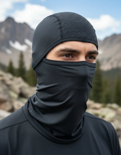 Hombre con balaclava de licra fría azul en la montaña
