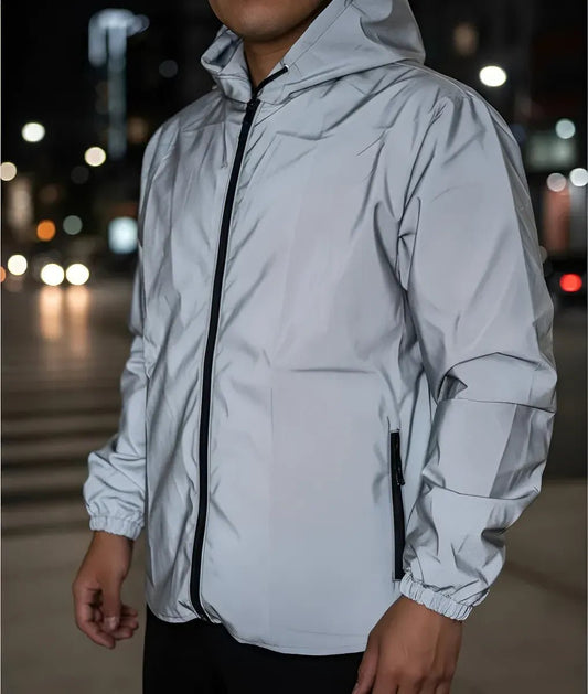 Hombre con chaqueta reflectiva gris de noche en la ciudad